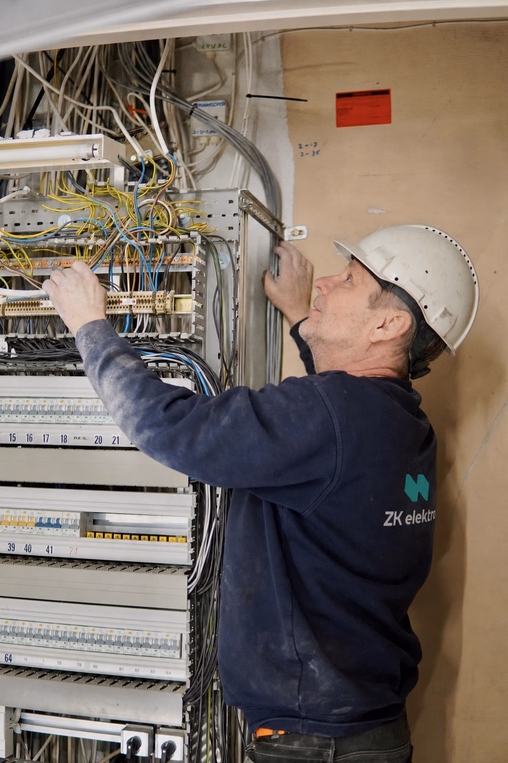 Montør fra ZK Elektro arbeider med kabler og tilkoblinger i en elektrisk tavle