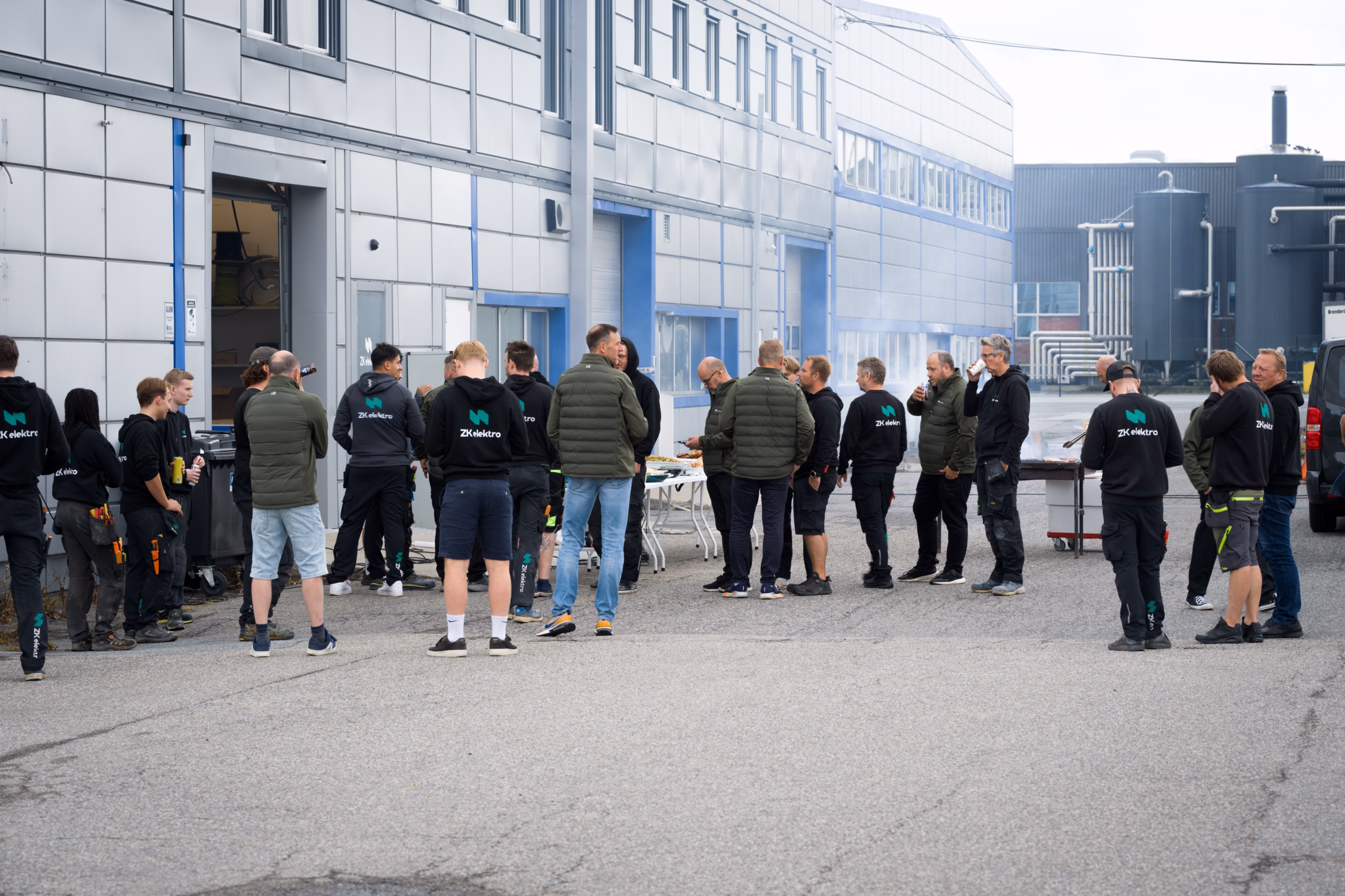 En større gruppe mennesker samlet rundt matserveringen utenfor et næringsbygg.